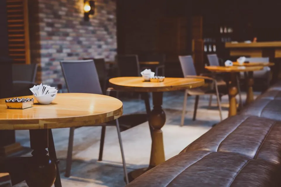 Cafetería con mesas de madera y banca tapizada