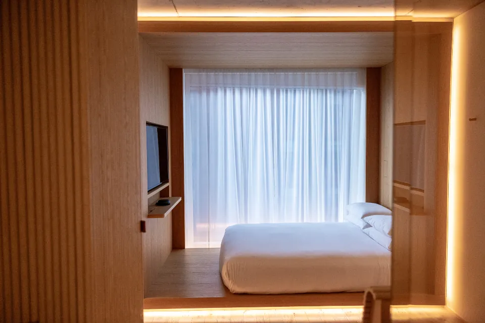 Dormitorio cálido con madera e iluminación indirecta